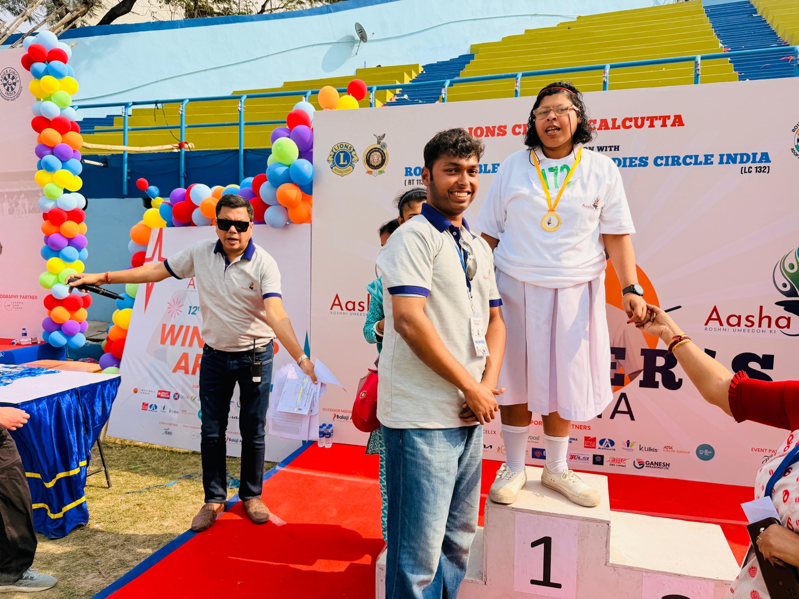 Handing out a medal on the podium at Aashayein 2026